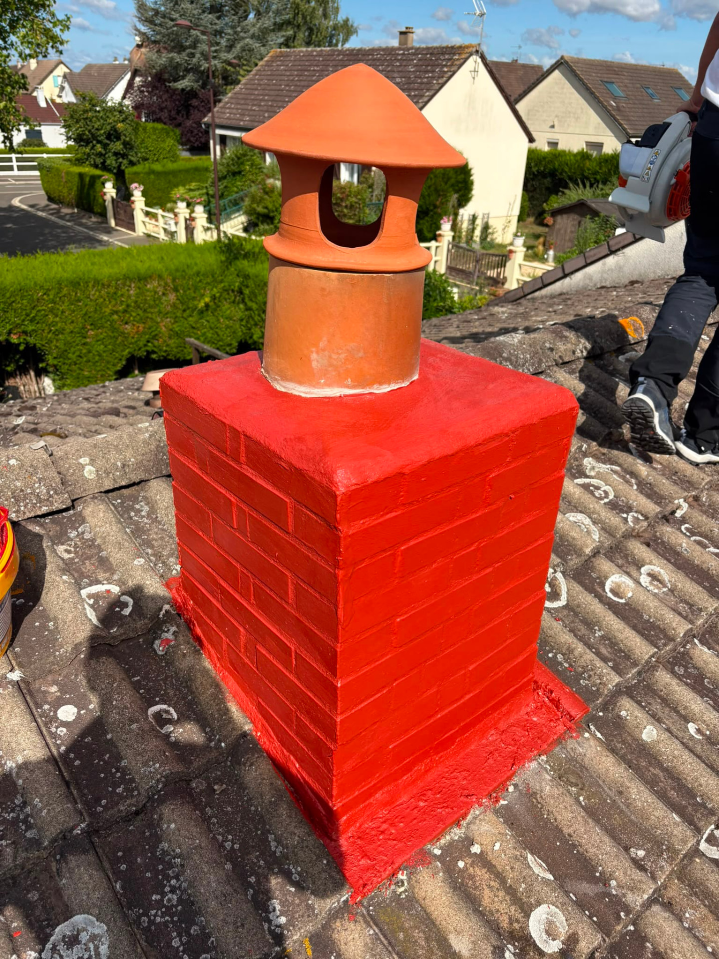 Cheminée en briques rénovée et repeinte en rouge avec mitre terre cuite neuve à Bonnières-sur-Seine